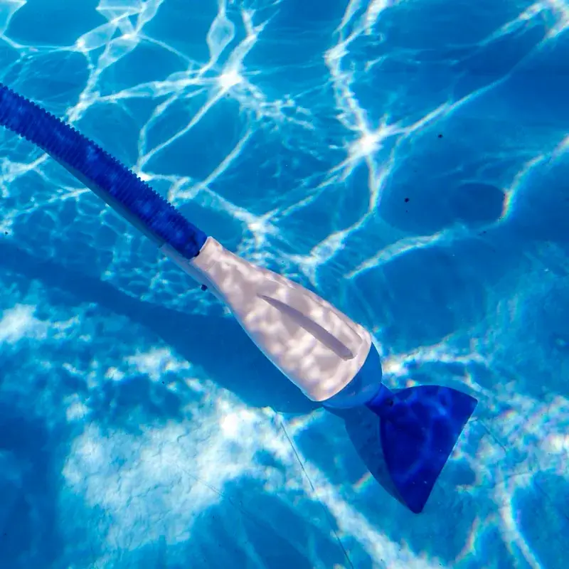 08011a-2 | PisciManía Blue pool vacuum head with white body attached to a blue hose underwater in a bright pool.