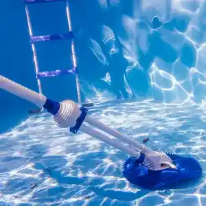 19001-2 | PisciManía Underwater pool cleaner with a hose and blue wheel-like base resting on the pool floor beside a metal ladder.