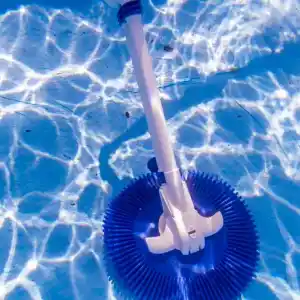19001-4 | PisciManía Underwater blue circular pool cleaner head attached to a white pole in a sunlit pool endcap with light reflections on the water surface