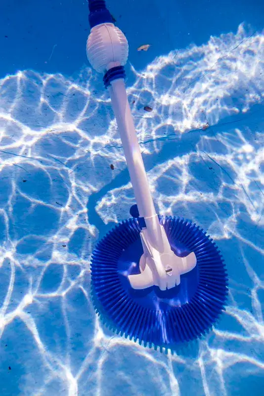 19001-4 | PisciManía Underwater blue circular pool cleaner head attached to a white pole in a sunlit pool endcap with light reflections on the water surface