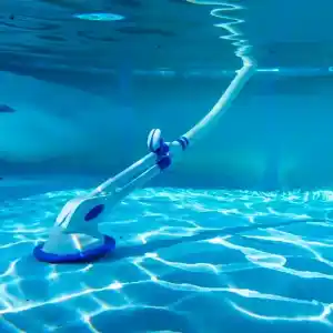 90399-1 | PisciManía Automatic pool cleaner with a long telescoping pole resting on the pool floor underwater in a blue pool