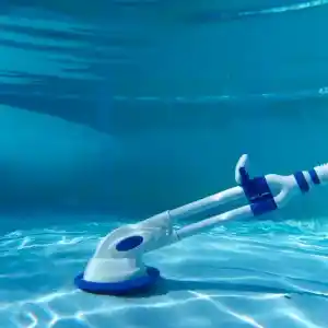 90399-3 | PisciManía Blue and white pool vacuum head with attached hose cleaning a clear blue pool underwater.