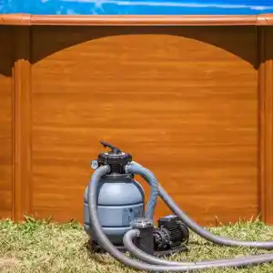 fs320-1 | PisciManía Blue above-ground pool with a gray sand filter and pump sitting on grass, hoses looping around it.