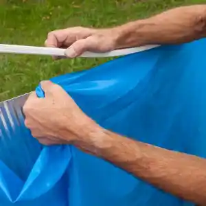 fpr241-2 | PisciManía Close-up of hands sealing a blue plastic bag with white tape outdoors, suggesting sealing a trash bag.