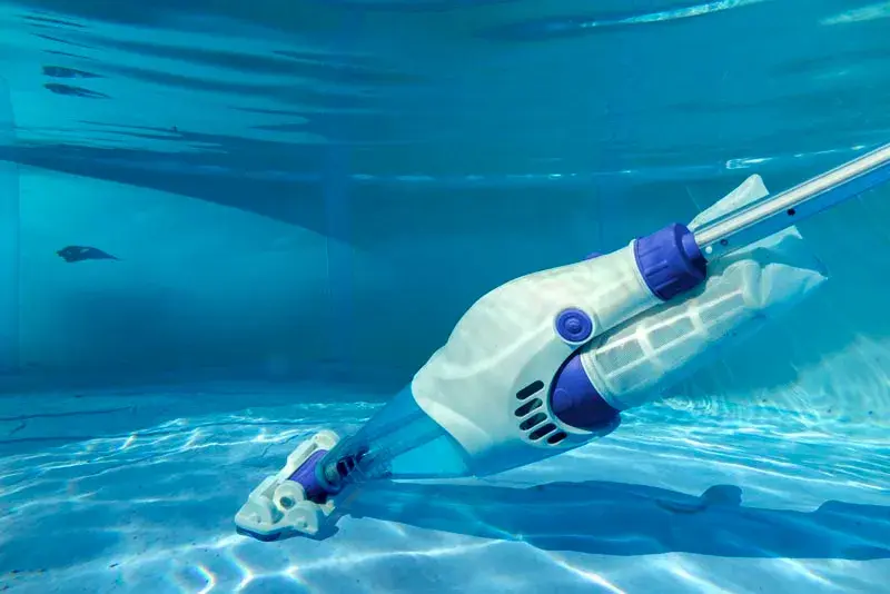 vcb10-4 | PisciManía White and purple robotic pool cleaner gliding along the pool floor underwater.