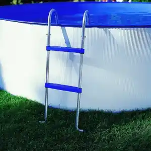 escaleras-para-piscinas-gre-1 | PisciManía Above-ground pool with a blue rim and silver ladder resting on green grass beside it.