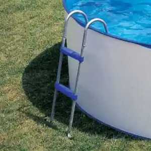 escaleras-para-piscinas-gre-2 | PisciManía Above-ground pool with a blue ladder resting on the grassy yard beside the pool edge.
