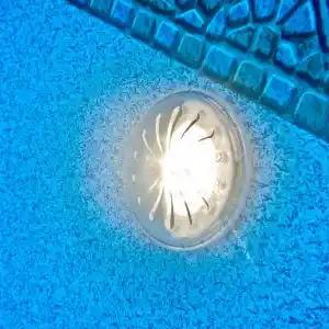 pled2-2 | PisciManía Circular recessed light on a blue textured surface with a metal grate pattern above.