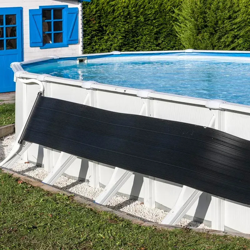 ar2069-2 | PisciManía Above-ground pool with a black safety cover partially rolled across the side, white frame, blue water, and a blue-shuttered shed behind a green hedge.