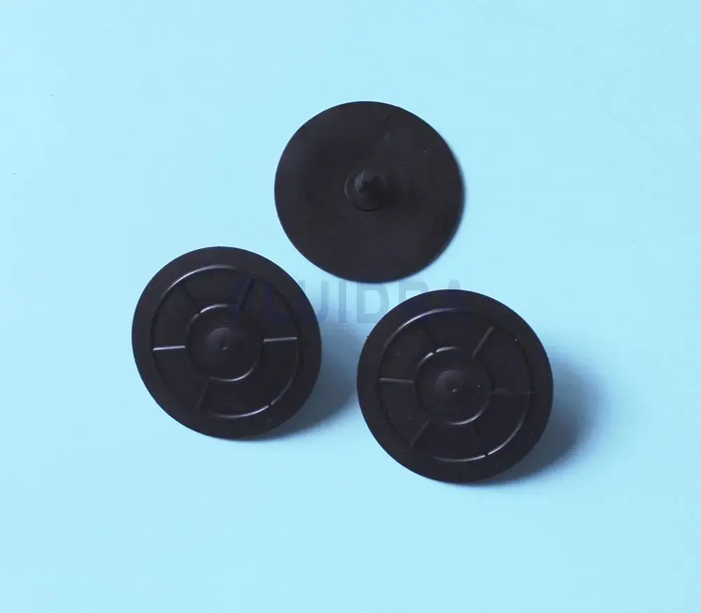 wr000189-2 | PisciManía Three small black circular plastic discs with a raised center and radial spokes on a light blue background.