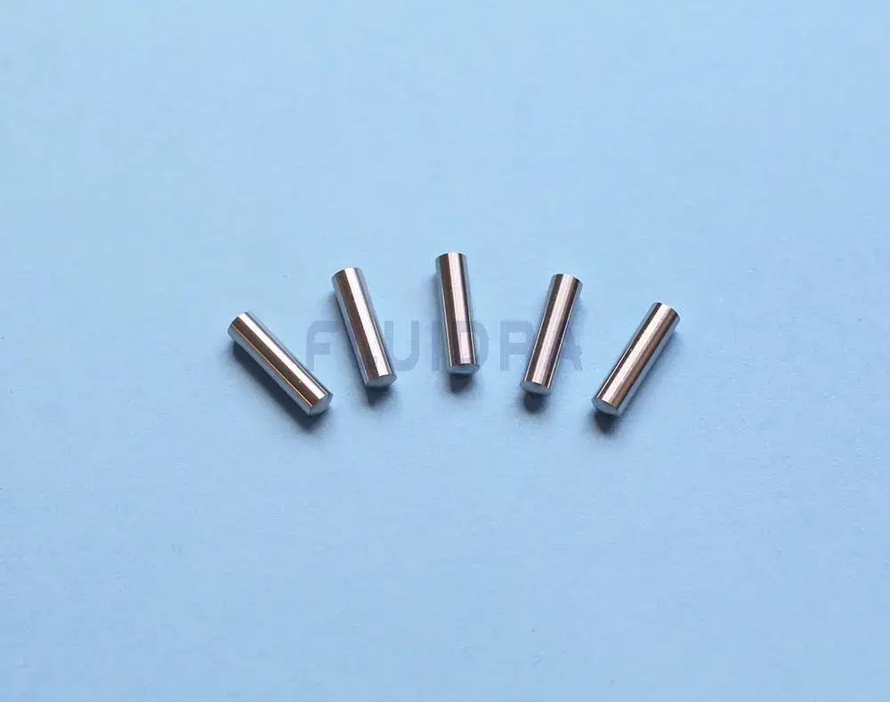 wr000189-3 | PisciManía Five small silver cylindrical metal pins scattered on a blue surface, likely dowel pins for mechanical alignment.